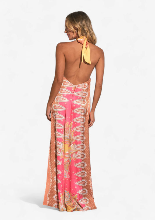 Woman wearing pink yellow and blue maxi halter dress at Mimiluca Boutique.