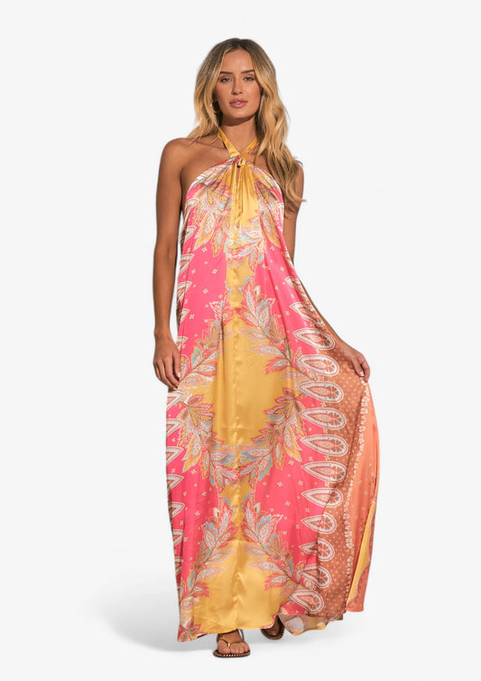 Woman wearing pink yellow and blue maxi halter dress at Mimiluca Boutique.