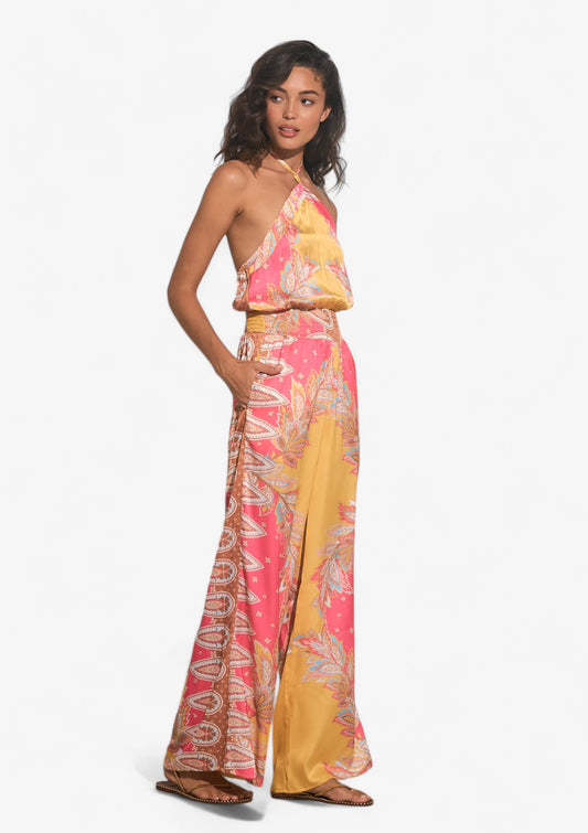 Woman wearing pink yellow paisley jumpsuit at Mimiluca Boutique.